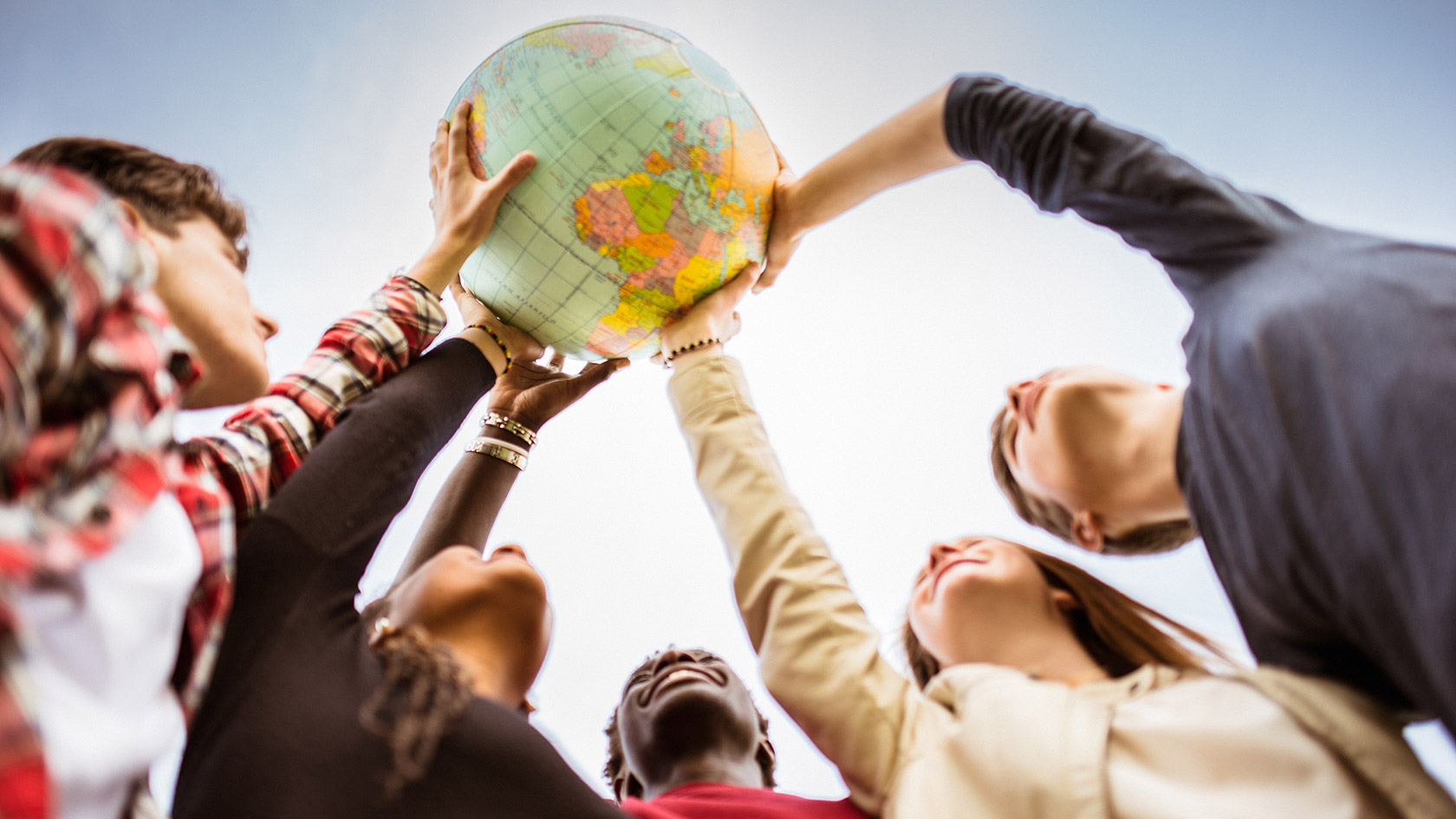 Students holding a globe