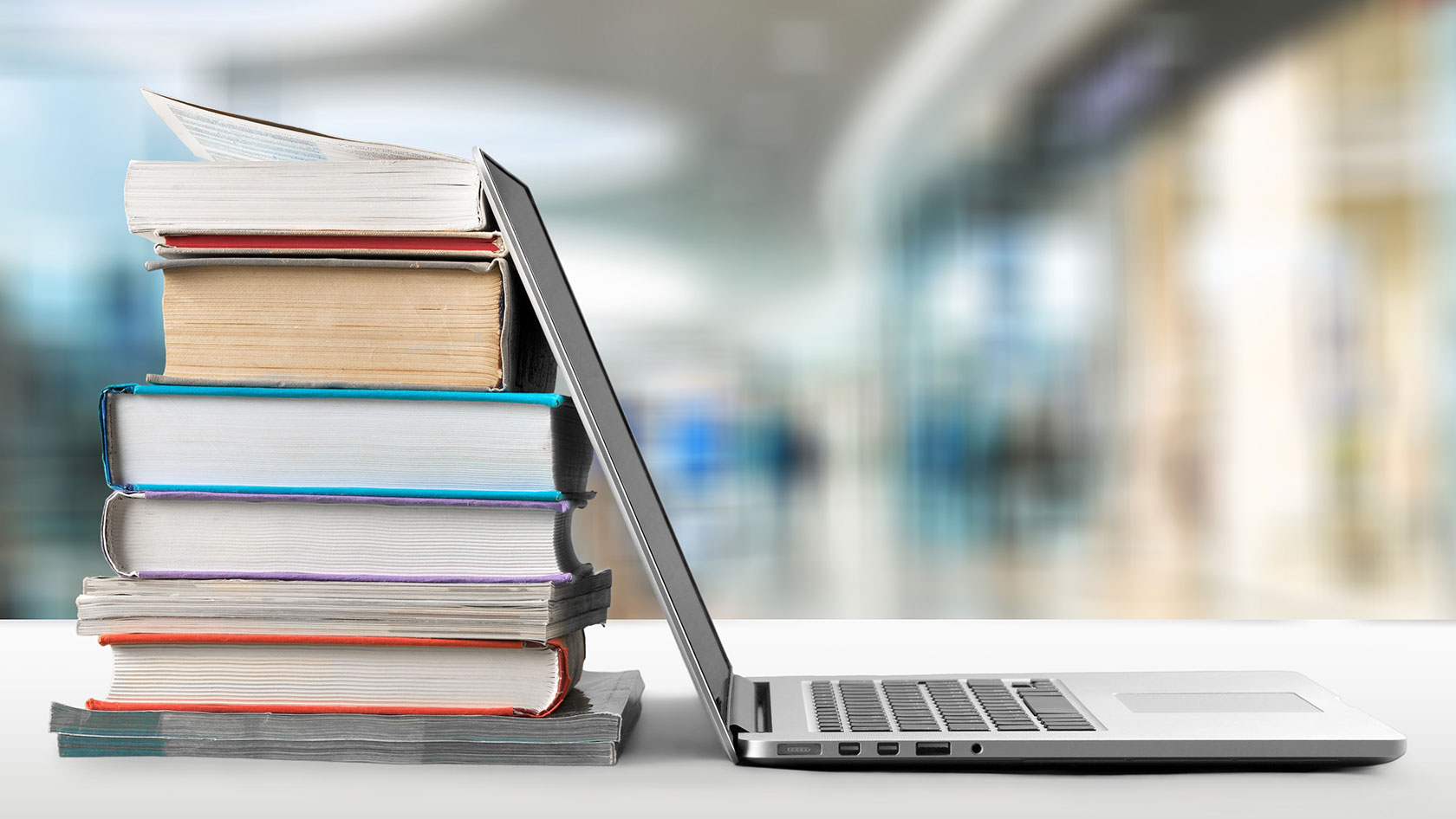 A laptop leaning on books